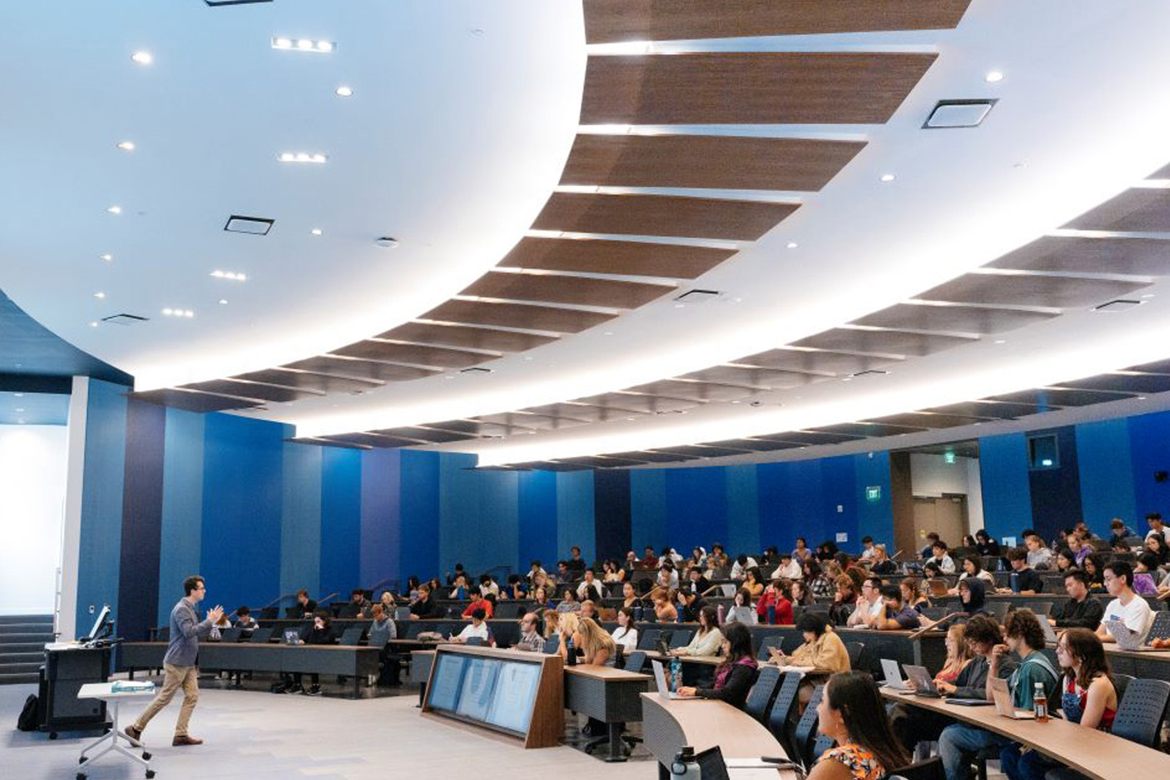 A person is standing infront of a large classroom